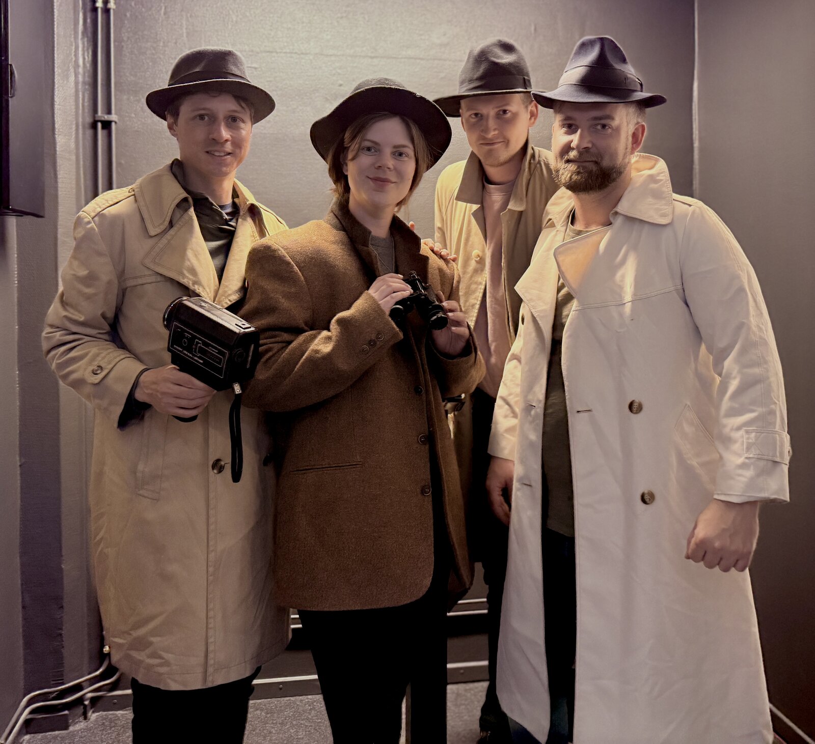 Erica, Martin, and friends in trench coats and fedoras at an escape room